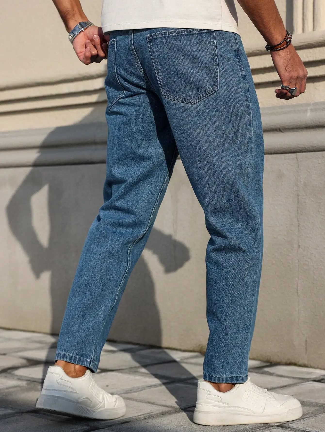 Les jeans pour hommes sont fabriqués en tissu denim bleu classique avec une coupe ample