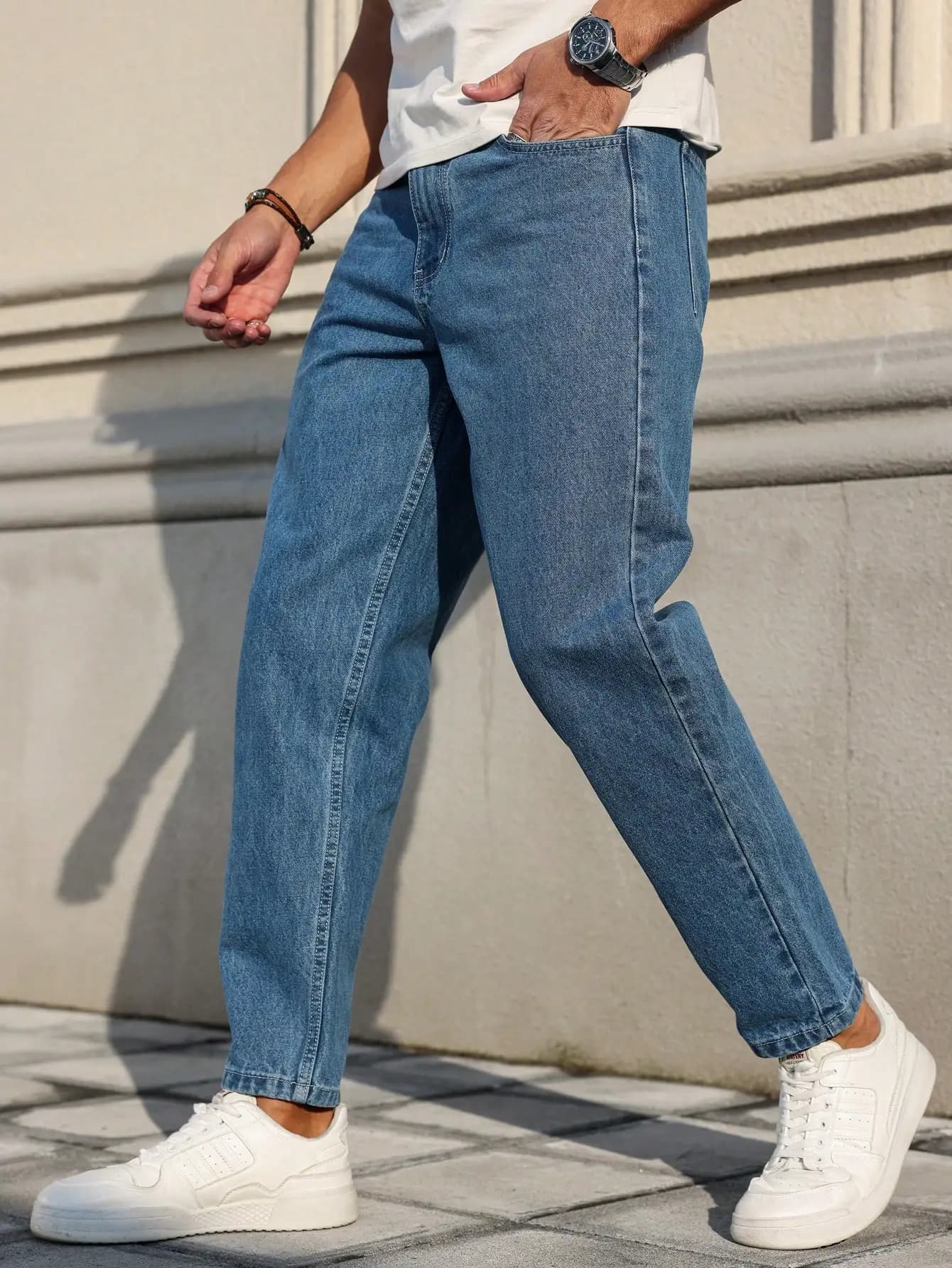 Les jeans pour hommes sont fabriqués en tissu denim bleu classique avec une coupe ample