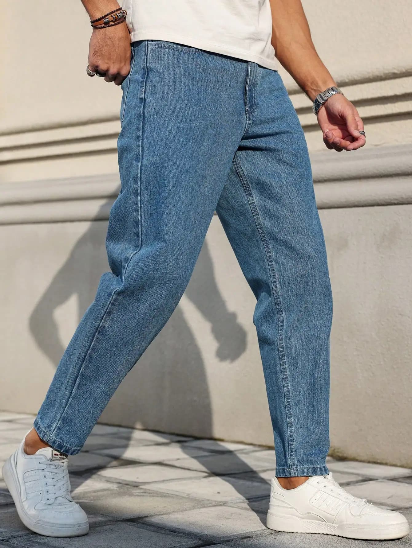 Les jeans pour hommes sont fabriqués en tissu denim bleu classique avec une coupe ample