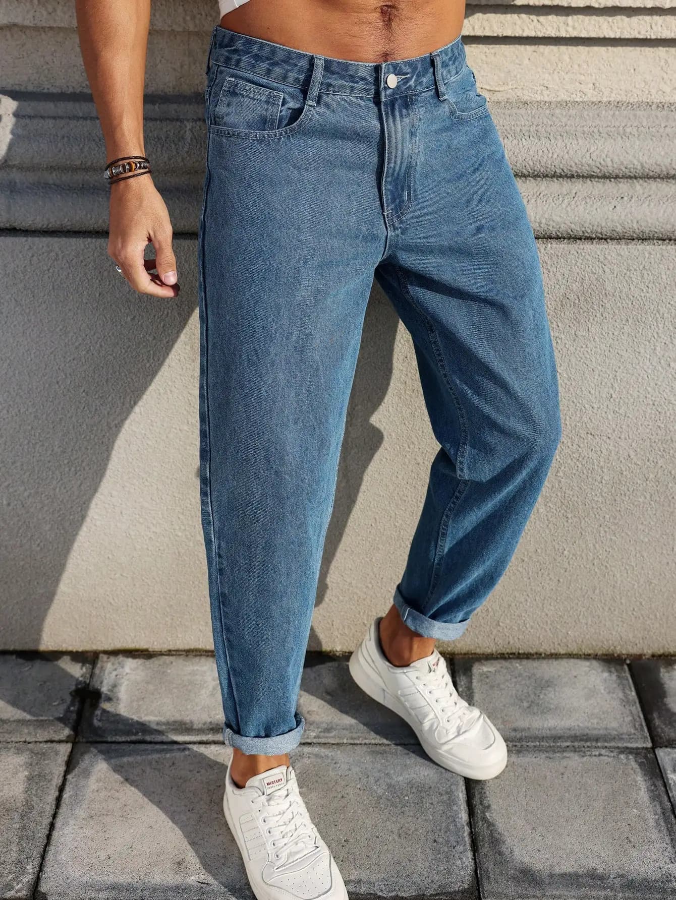 Les jeans pour hommes sont fabriqués en tissu denim bleu classique avec une coupe ample